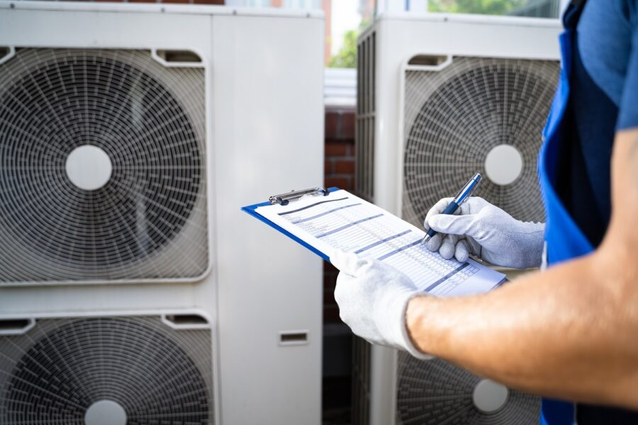 Two,Electricians,Men,Wearing,Safety,Jackets,Checking,Air,Conditioning,Unit
